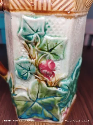 Antica caraffa in ceramica vintage con foglie e frutti