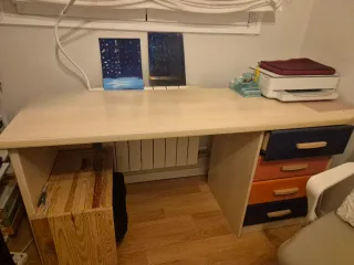 Escritorio beige con cajones azules y naranjas