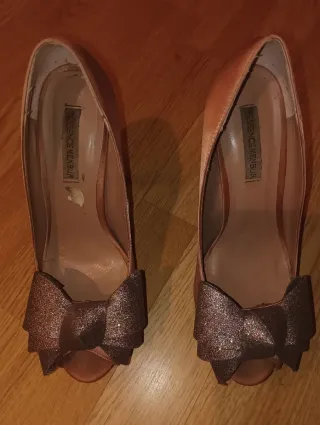 Zapatos de tacón dorados y rosas con lazo