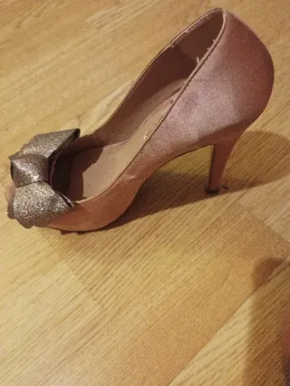 Zapatos de tacón dorados y rosas con lazo