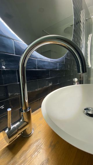 Mueble moderno de baño con lavabo y grifo.