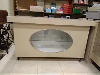 Mostrador de tienda beige con vitrina ovalada