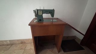 Máquina de coser clásica en mueble de madera