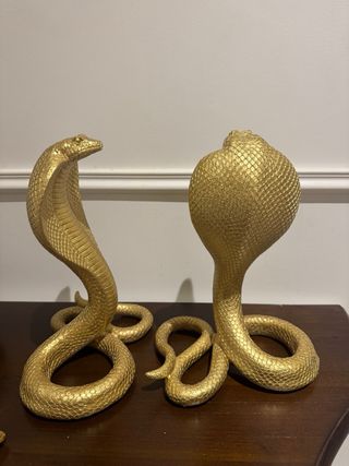 Par de figuras de serpientes doradas