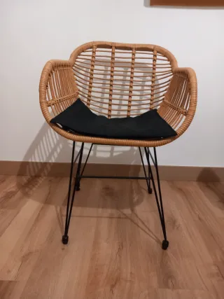 2 Sillas de ratán con cojín negro.