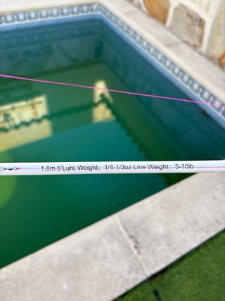 Caña y carrete de pesca spinning púrpura