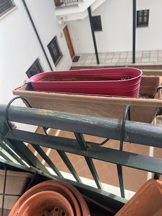 Jardinera verde y maceteros terracota