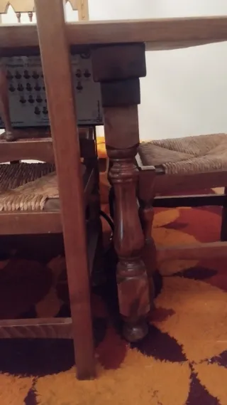 Mesa de madera con sillas, aparador y estanterías