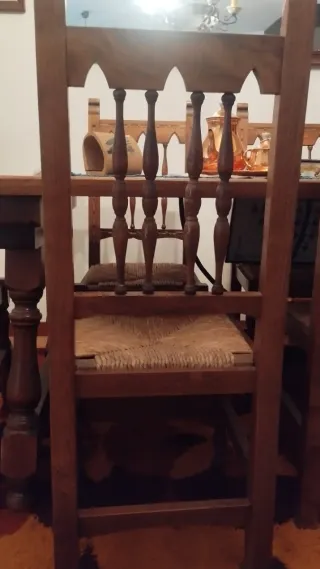 Mesa de madera con sillas, aparador y estanterías