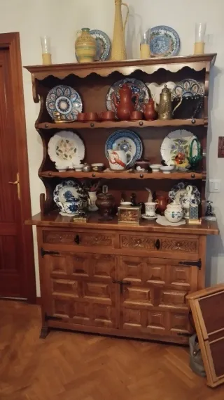 Mesa de madera con sillas, aparador y estanterías