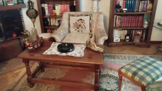 Mesa de madera con sillas, aparador y estanterías