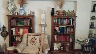 Mesa de madera con sillas, aparador y estanterías