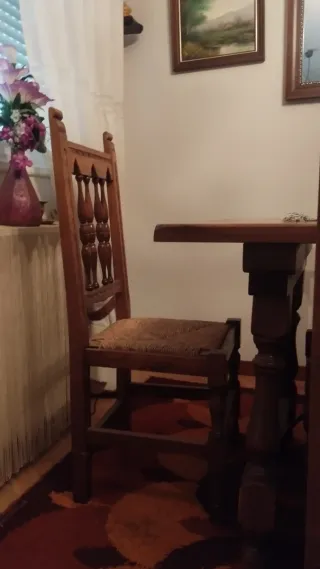 Mesa de madera con sillas, aparador y estanterías