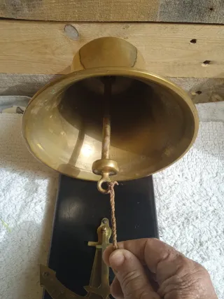 Campana de bronce con base de madera