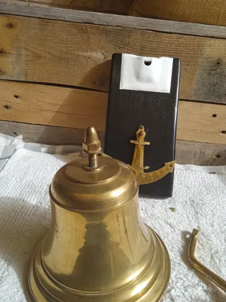 Campana de bronce con base de madera