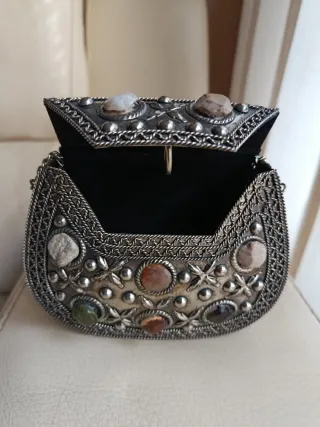 Bolso de mano plateado con piedras