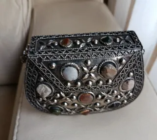 Bolso de mano plateado con piedras