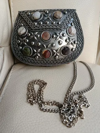 Bolso de mano plateado con piedras