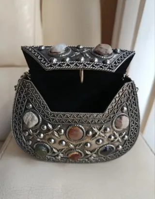 Bolso de mano plateado con piedras