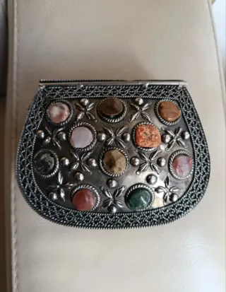 Bolso de mano plateado con piedras