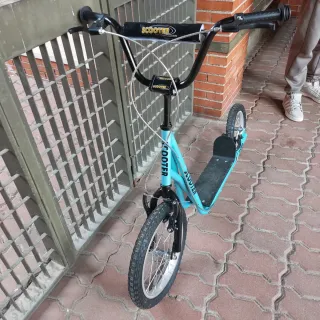 Patinete azul con ruedas grandes