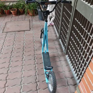 Patinete azul con ruedas grandes