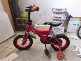 Bicicleta infantil roja con ruedines