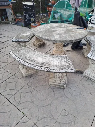 Mesa de piedra redonda con bancos