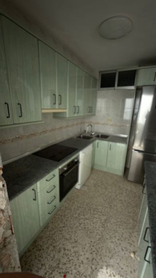 Cocina con encimera ta, fregadero y campana