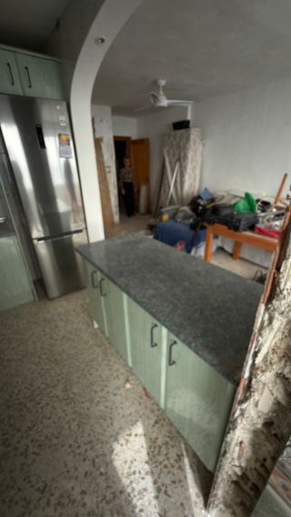 Cocina con encimera ta, fregadero y campana