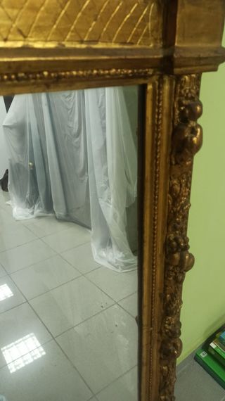 Espejo dorado con marco tallado