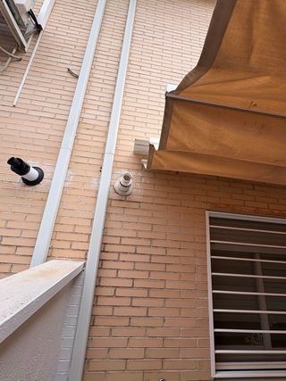 Tenda per pergola in alluminio bianco a parete.
