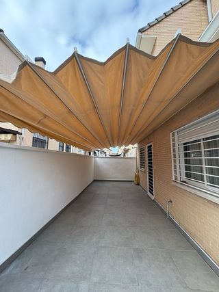 Tenda per pergola in alluminio bianco a parete.