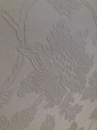 Cabecero de tela beige con bordado floral.