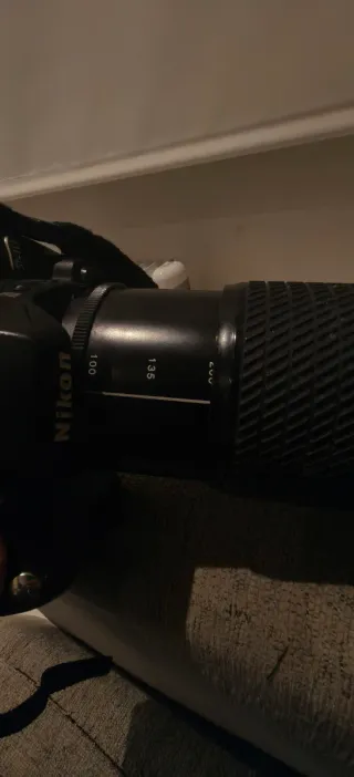 Fotocamera Nikon con obiettivo e caricabatterie