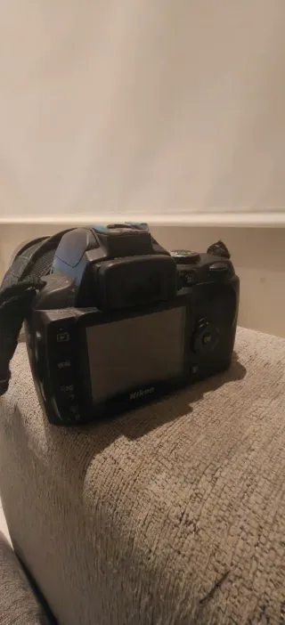 Fotocamera Nikon con obiettivo e caricabatterie