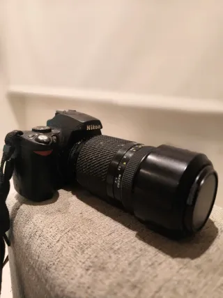 Fotocamera Nikon con obiettivo e caricabatterie