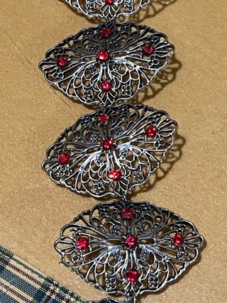 Pulsera plateada con piedras rojas