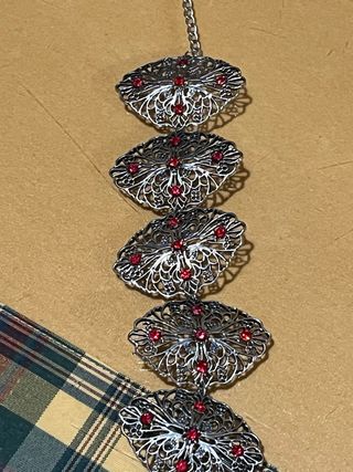 Pulsera plateada con piedras rojas