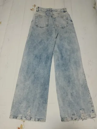 Pantalón vaquero ancho deshilachado.