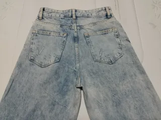 Pantalón vaquero ancho deshilachado.