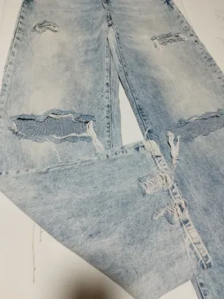 Pantalón vaquero ancho deshilachado.