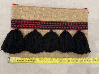 Bolso de mano de yute con borlones negros