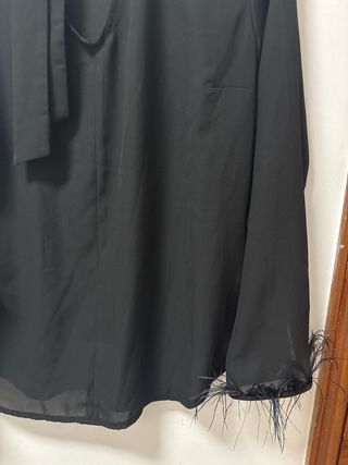 Camiseta negra con lazo y plumas