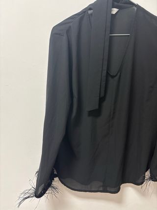 Camiseta negra con lazo y plumas