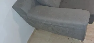 Sofá gris de tela en buen estado con señal de uso