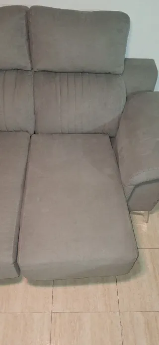 Sofá gris de tela en buen estado con señal de uso