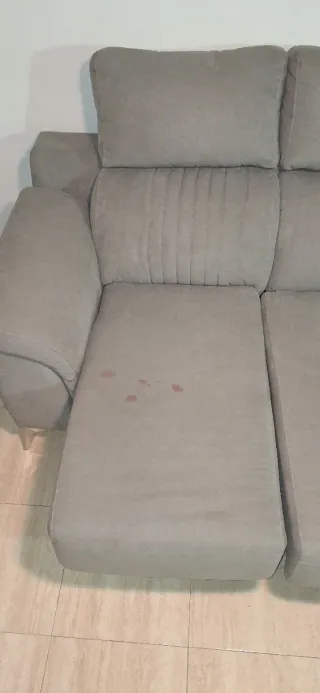 Sofá gris de tela en buen estado con señal de uso