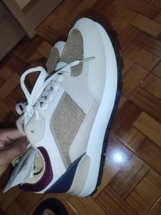 Zapatillas deportivas doradas y blancas