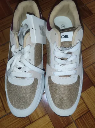Zapatillas deportivas doradas y blancas